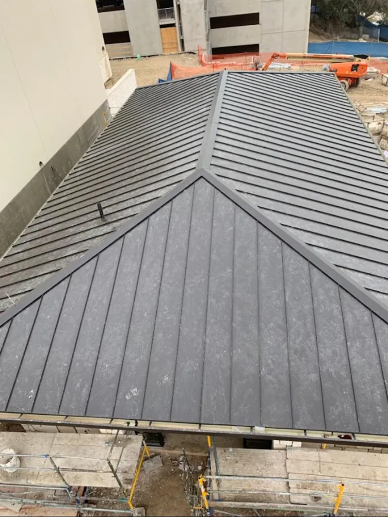 Commercial metal roof construction with crane equipment in Lucas